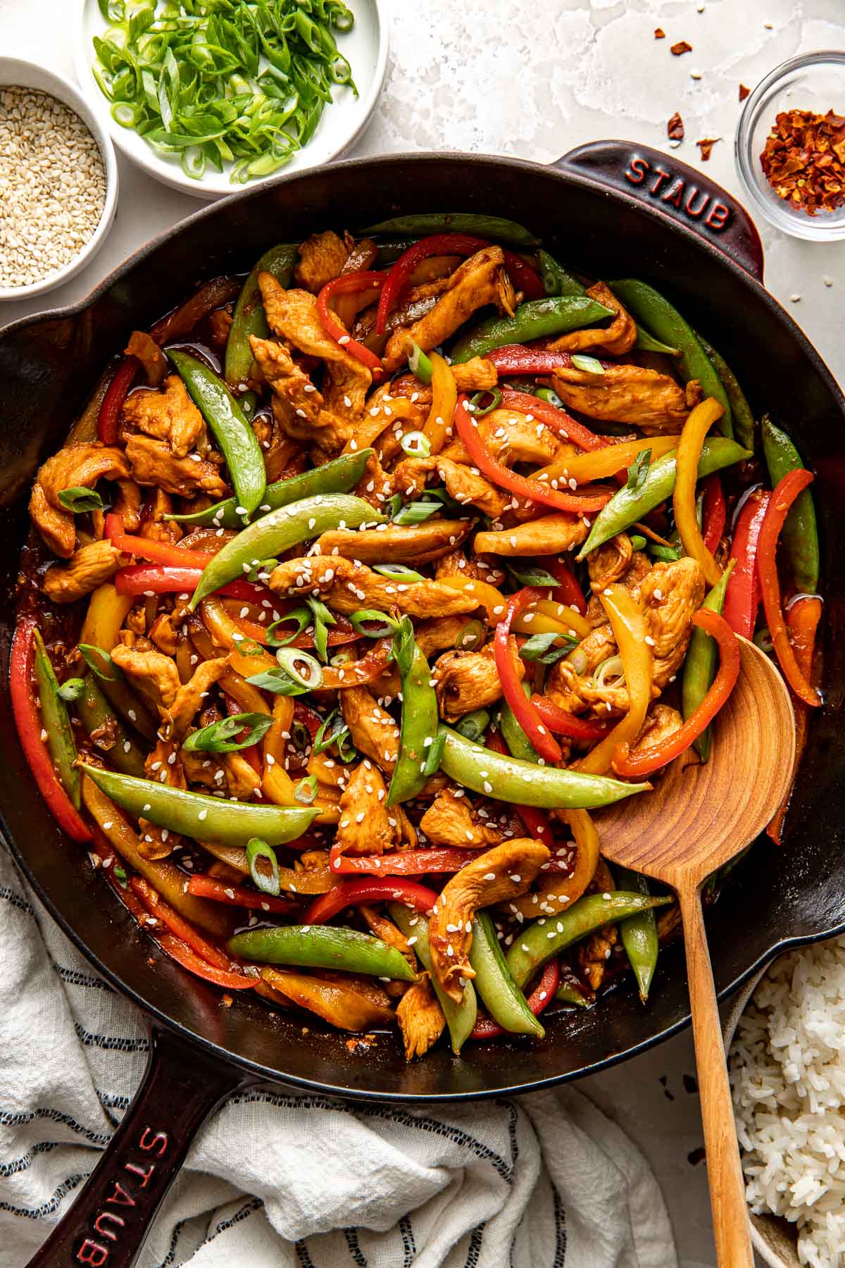 Overhead view of a skillet filled with colorful Chicken Stir Fry topped with sesame seeds.