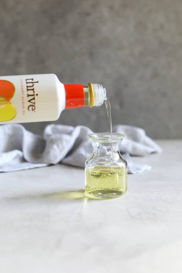 Thrive Culinary Algae Oil being poured into a glass bottle