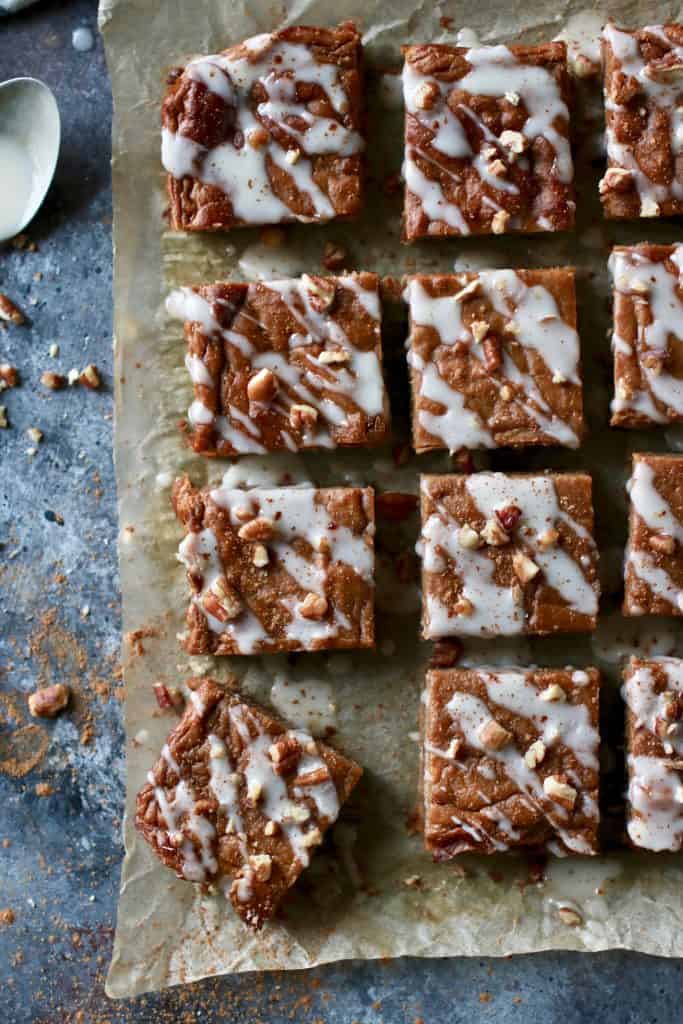 Overhead view pumpkin pie bars cut into squares drizzled with white frosting.
