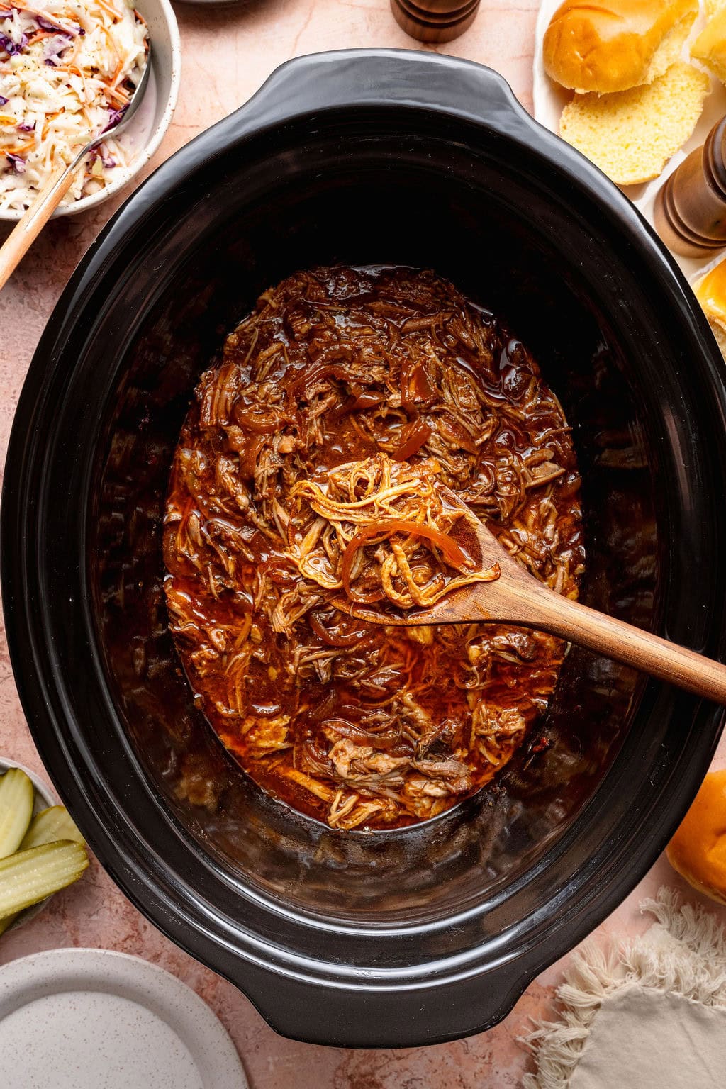 Overhead view of a slow cooker filled with Pulled Pork BBQ mixture.