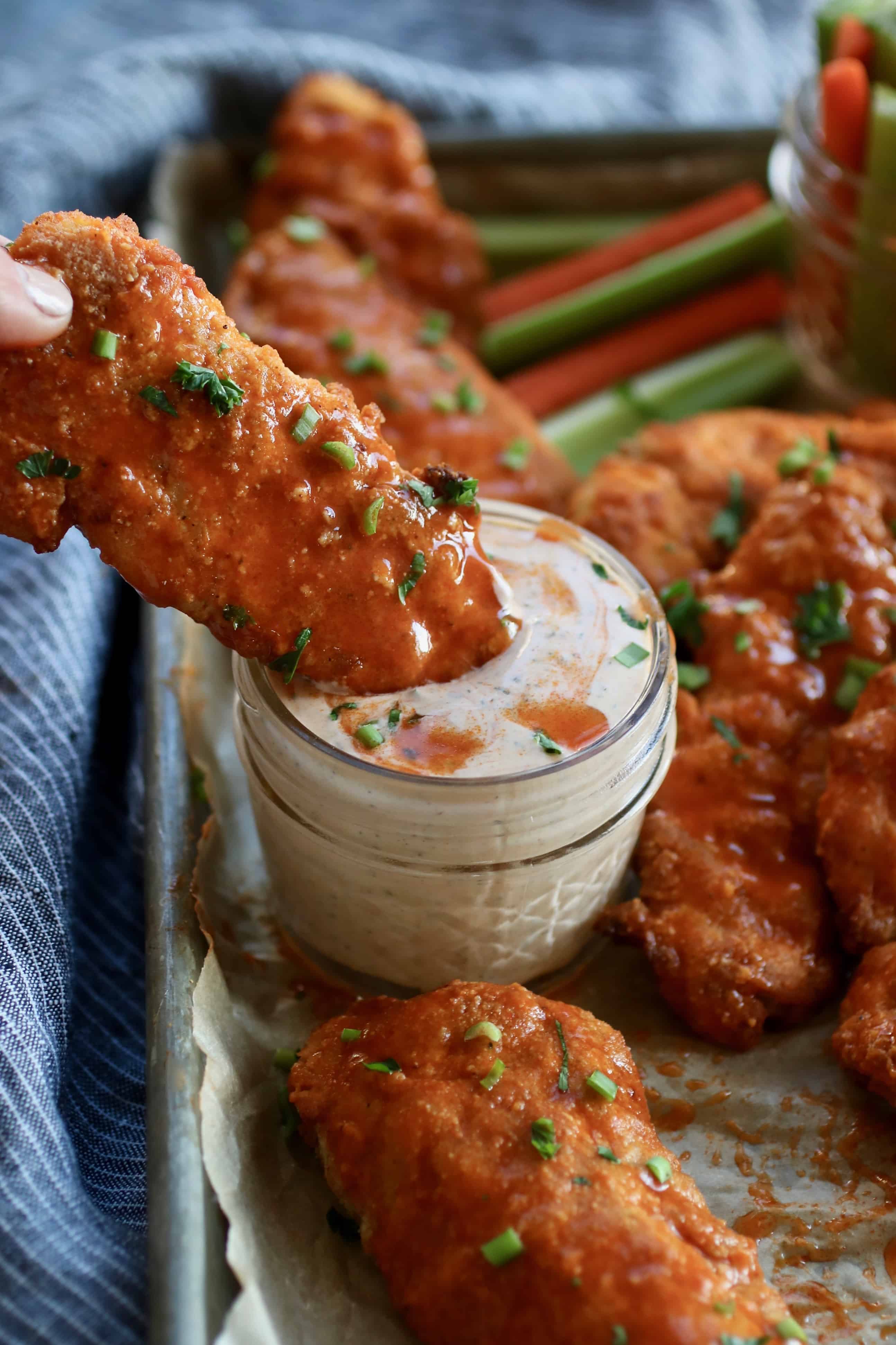 Buffalo Chicken Strips dunked into a ranch dip. 