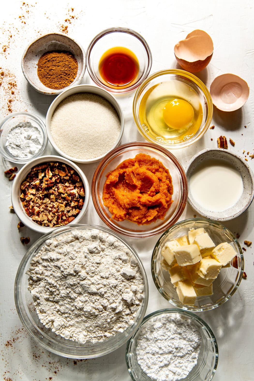 Overhead view of a variety of ingredients for Gluten-Free Pumpkin Spice Scones in different sized bowls. 