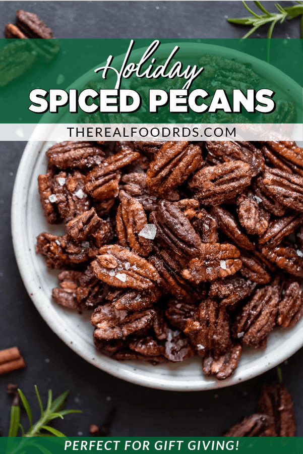 Holiday spiced pecans infused with cinnamon and maple syrup on a speckled white plate