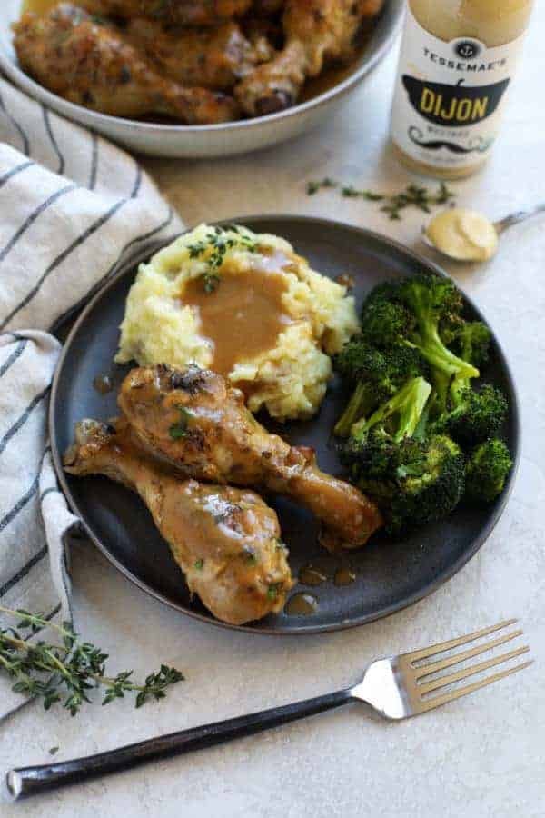 Overhead view of a plate of two chicken wings on a plate with mashed potatoes & gravy and broccoli 