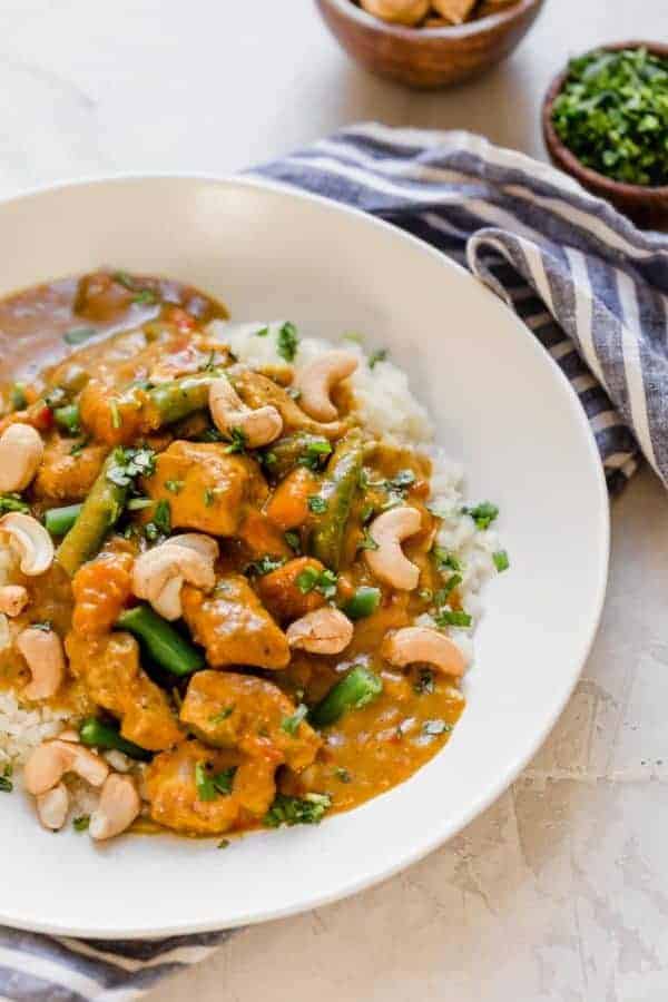 Slow Cooker Sweet Potato Chicken Curry in a white bowl served over cauliflower rice.