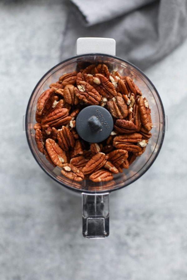 Overhead view small food processor filled with pecans.