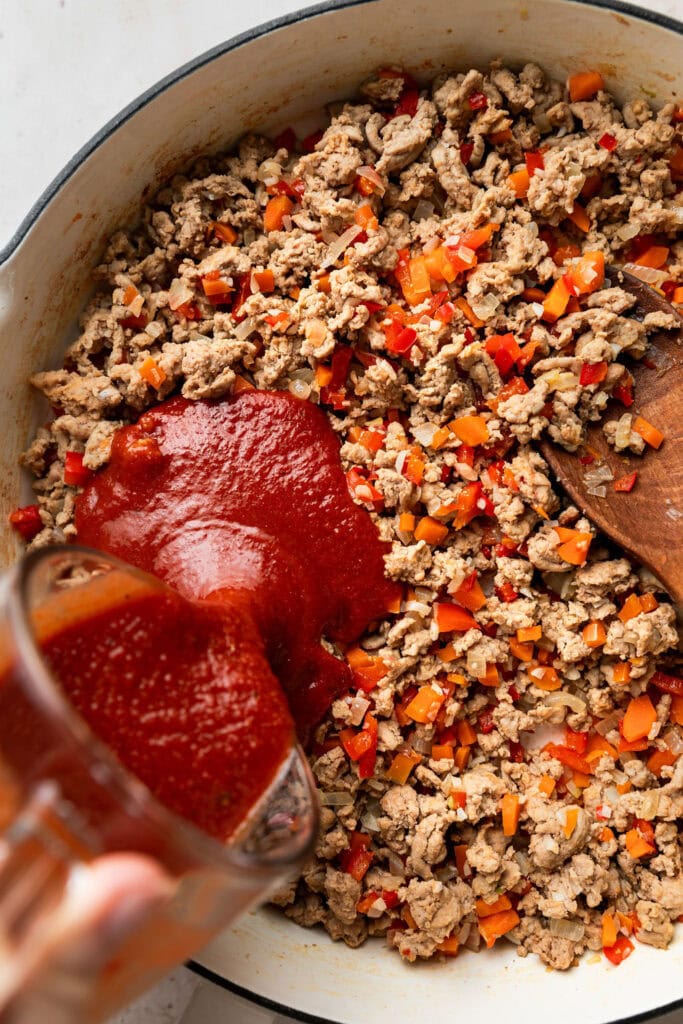 Ground turkey sloppy joe ingredients being stirred together in a pan. 