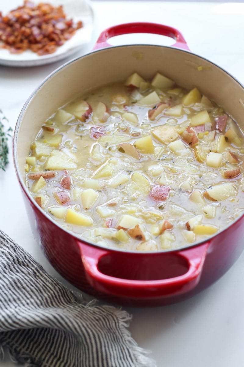 Potato leek soup cooking in a red stock pot