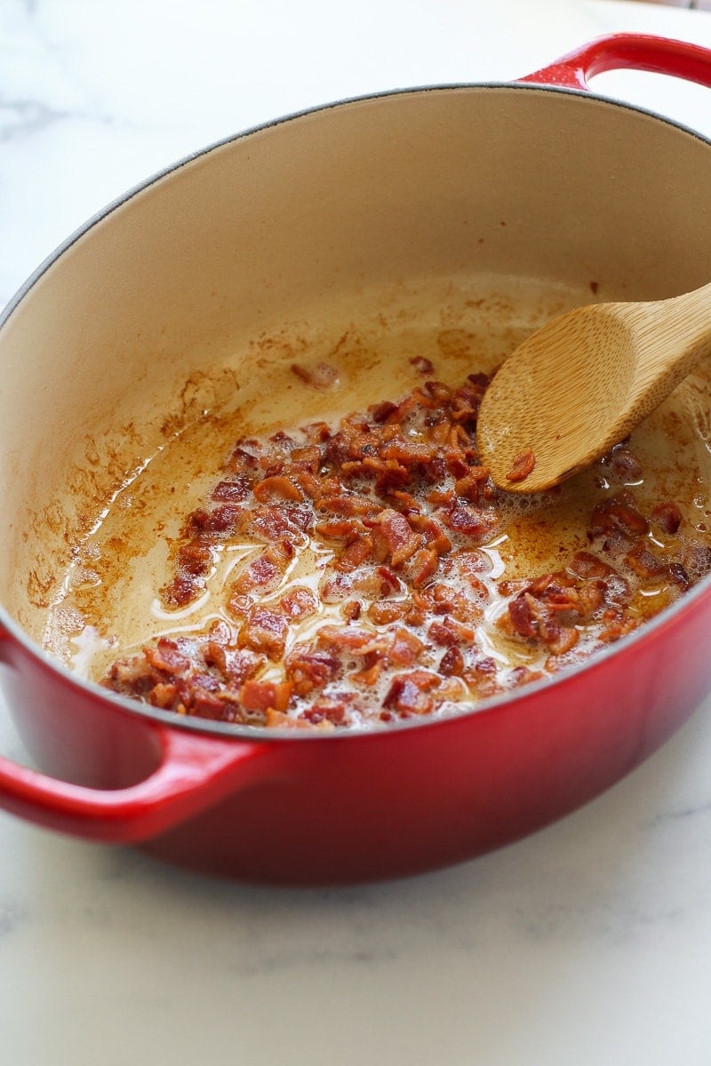 Bacon crumbles cooking in a red pan