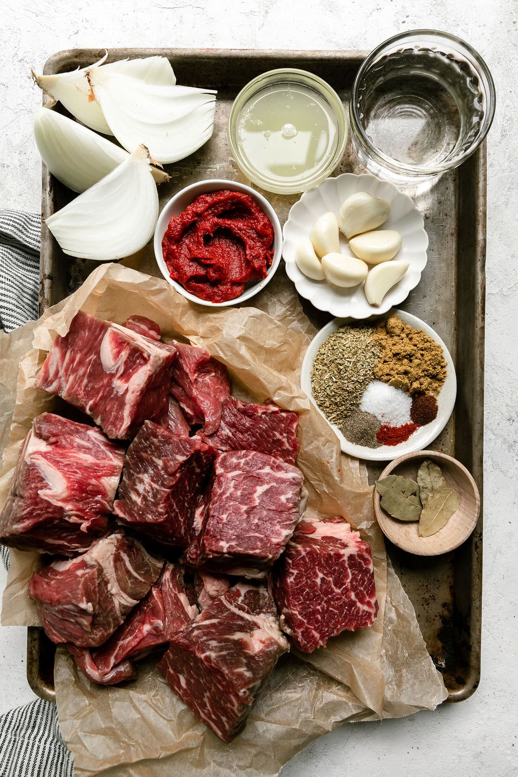 All ingredients for slow cooker beef barbacoa on baking sheet.