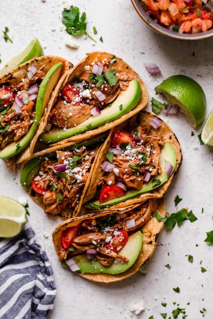 Chicken tacos wrapped in corn shells placed together in bundle of five tacos