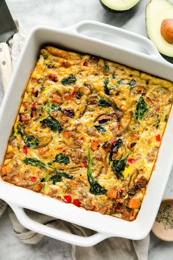Baked egg bake with sweet potatoes and spinach in white baking dish
