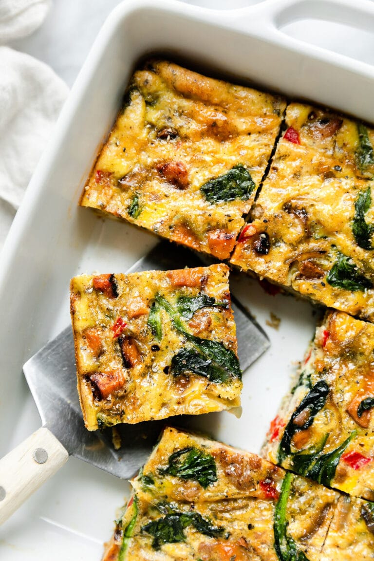 Sweet Potato Turkey Sausage Egg Bake cut into square and being taken out of a casserole pan. 