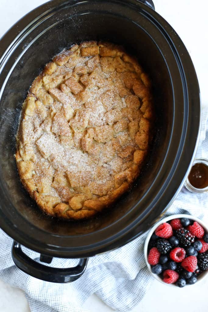 Slow cooker with French Toast Casserole with a side of berries and maple syrup
