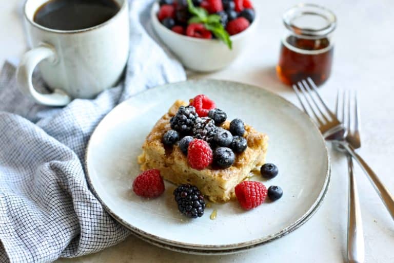 A serving of Slow Cooker French Toast Casserole on plate topped with fresh berries