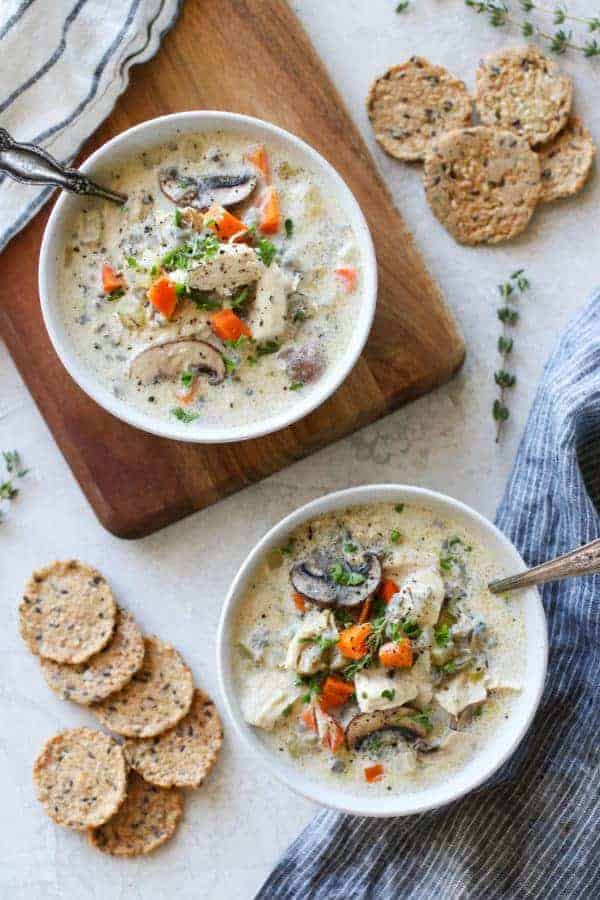 Overhead photo of two white bowls of Slow Cooker Creamy Chicken Wild Rice Soup.