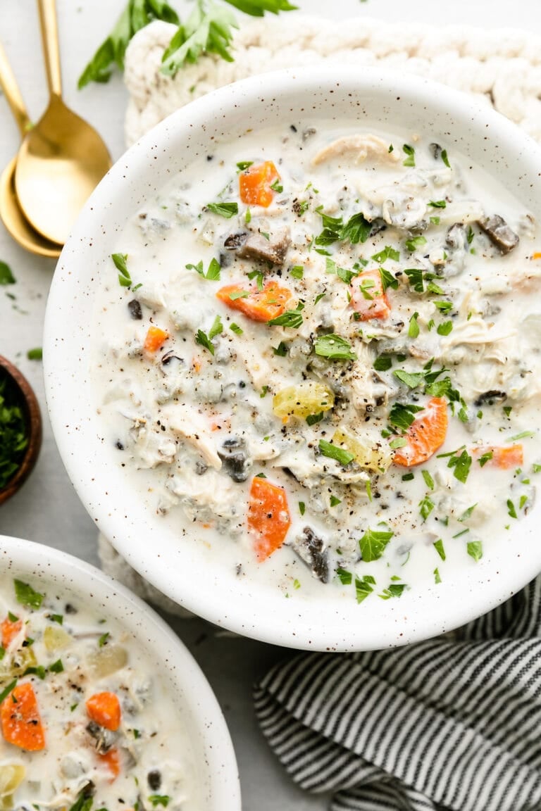 Overhead view of a bowl of chicken wild rice soup topped with black pepper. 