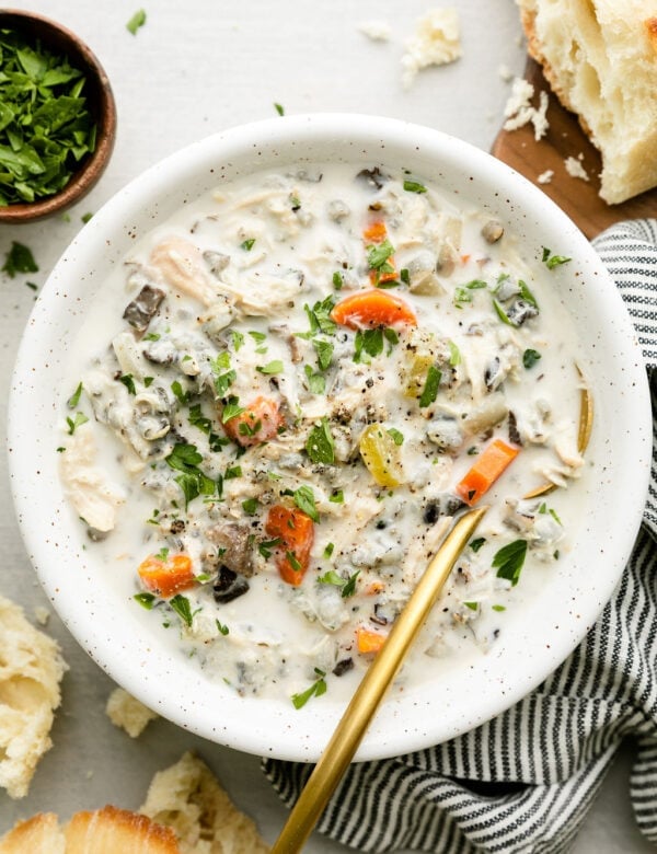 Overhead view white bowl filled with creamy chicken wild rice soup