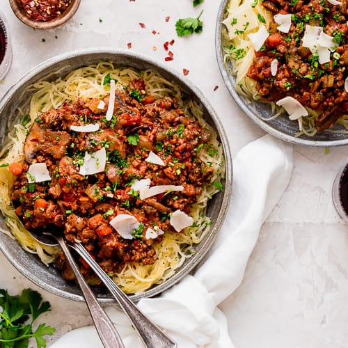 Overhead view instant pot turkey mushroom bolognese served over spaghetti squash strands in stone bowl