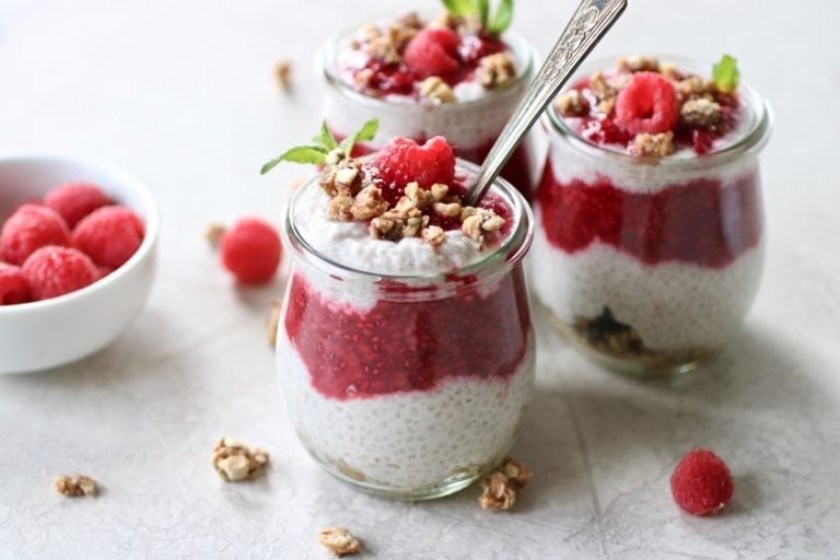 Close up view of Raspberry Chia Pudding parfaits topped with granola. 