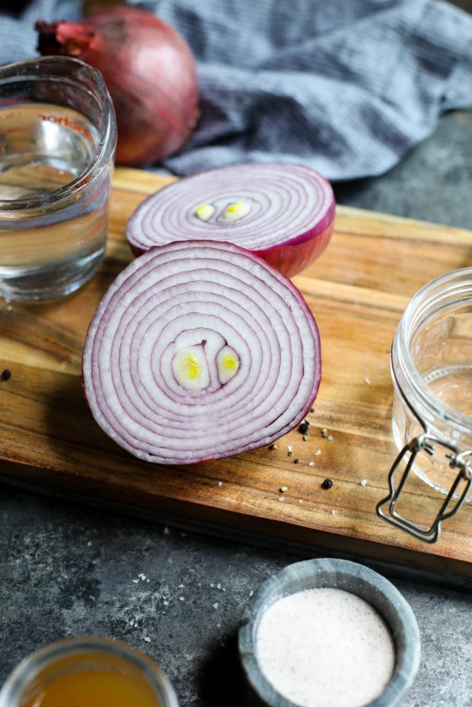 Red onions rounds on a wooden cutting board