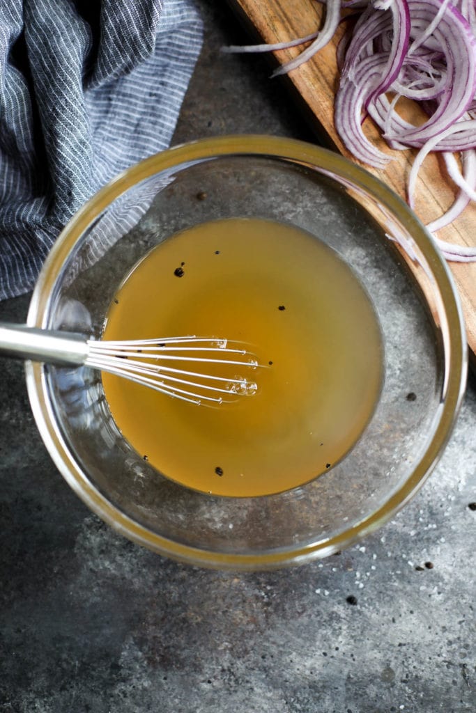 Overhead view of a bowl filled with liquid mixture for quick pickled onions.