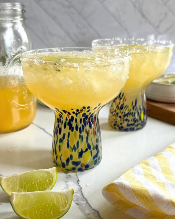 Close up view of two margaritas in festive glasses.