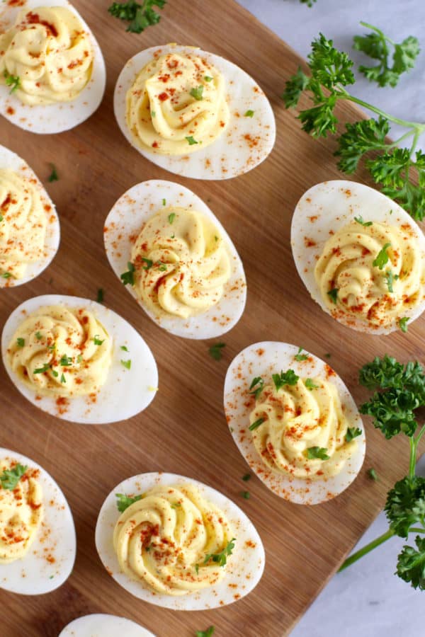 An overhead view of deviled eggs made with Greek yogurt on a cutting board