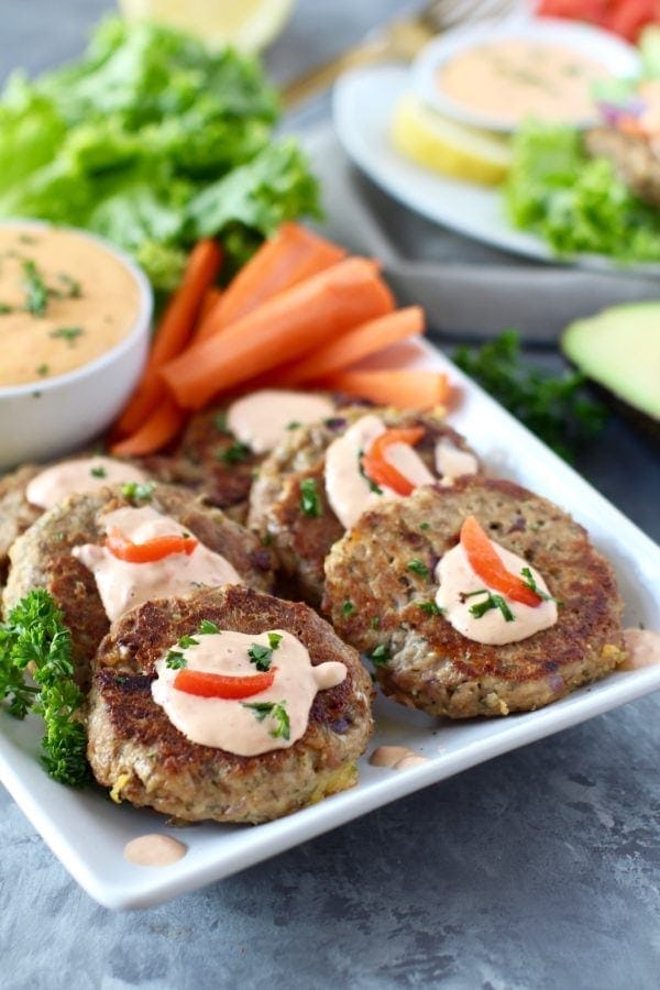 Photo of Easy Tuna Cakes with Red Pepper Mayo on a tray with carrot sticks. Photo is linked to the recipe. 