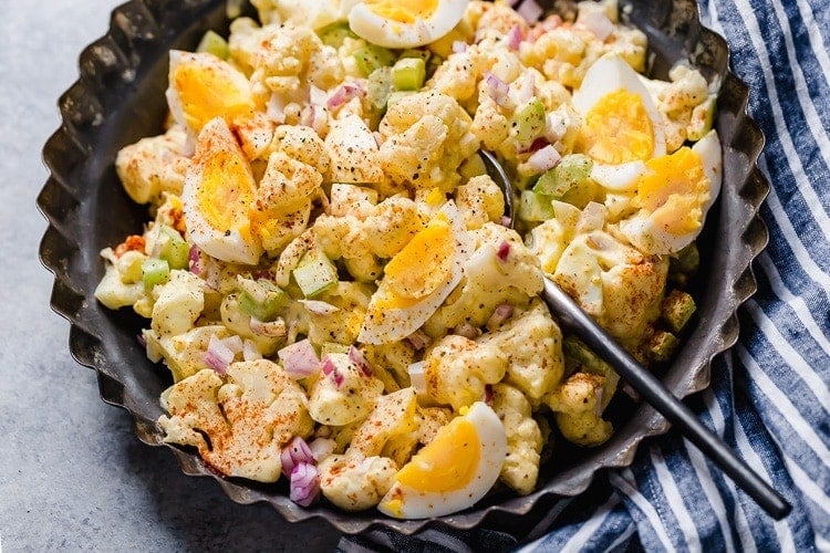 Low carb mock potato salad being scooped up with serving spoon