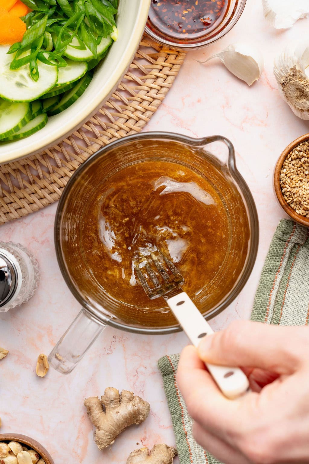Overhead view of a small measuring glass filled with Asian dressing.