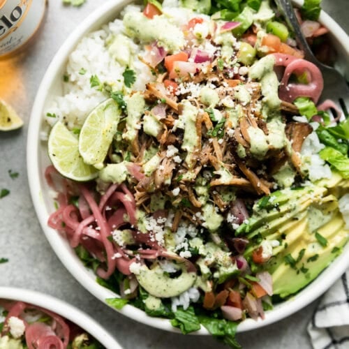 Overhead view of slow cooker carnitas in a carnitas burrito bowl