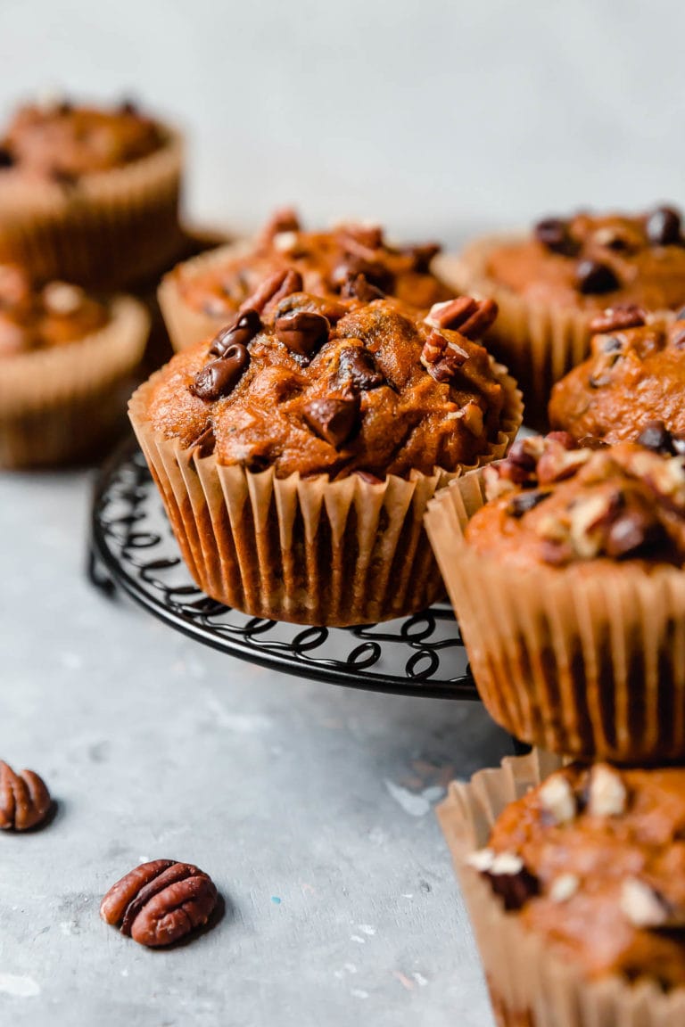 A cooling rack filled with freshly baked Gluten-free Pumpkin Chocolate Chip Muffins.