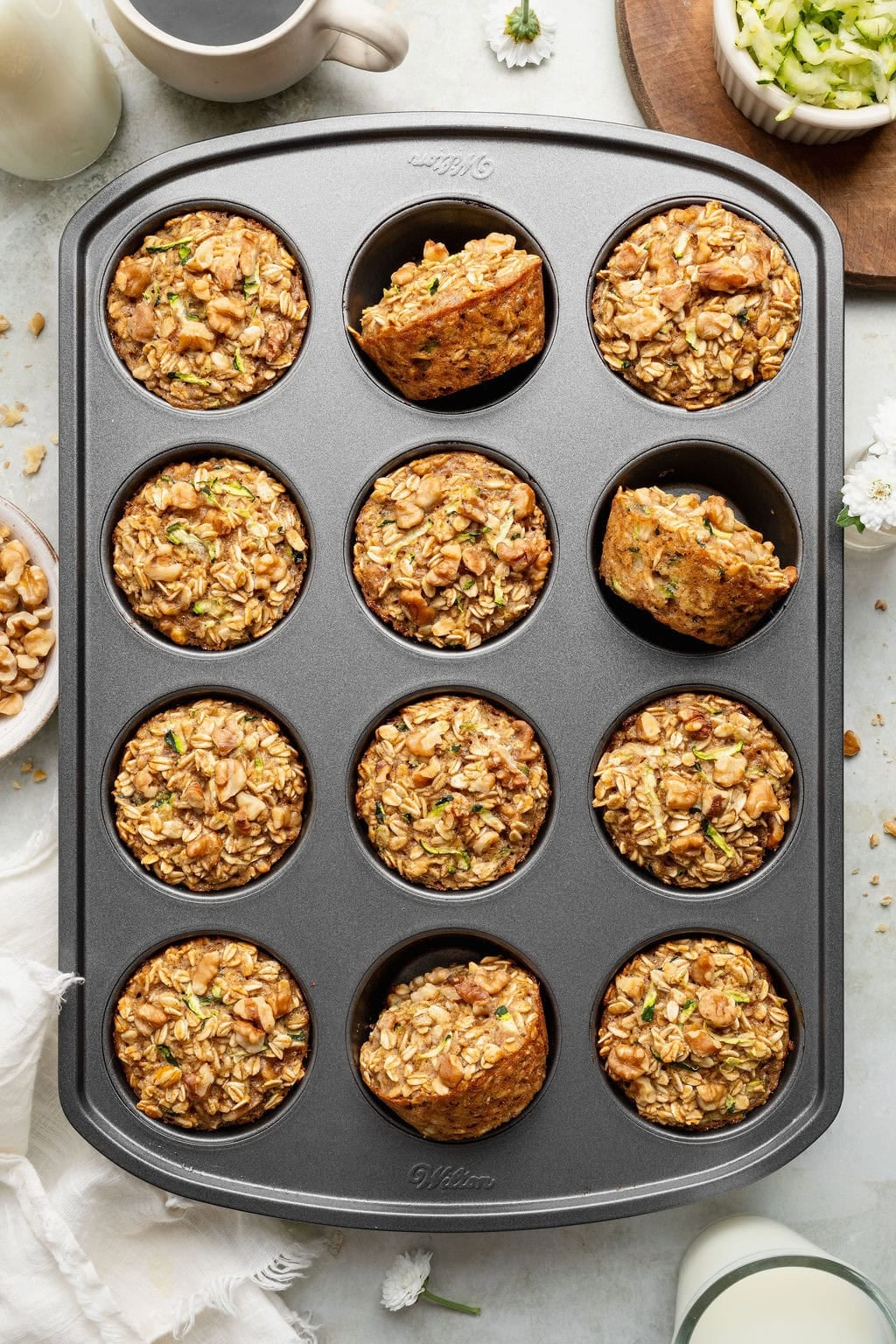 Baked oatmeal cups with walnuts and zucchini in a muffin tin.