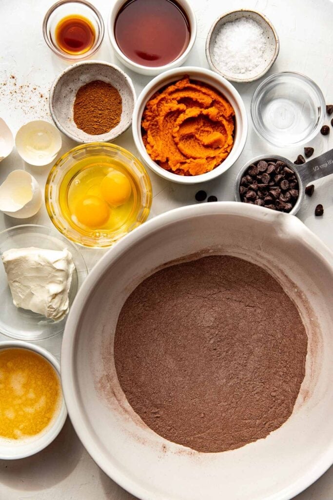 Overhead view of a variety of ingredients for Pumpkin Brownies in different bowls.