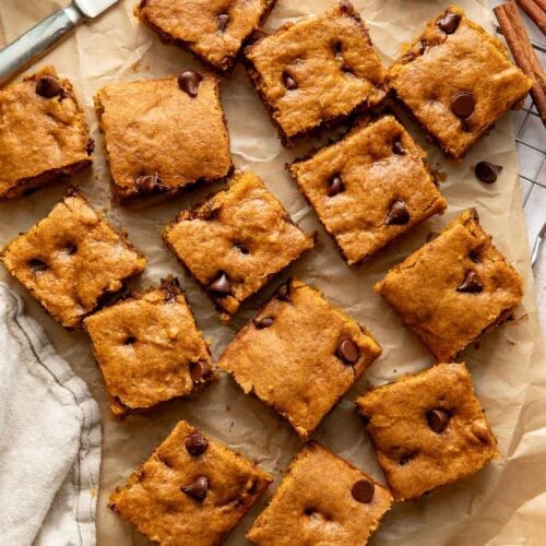 Pumpkin chocolate chip bars on a sheet of parchment paper.