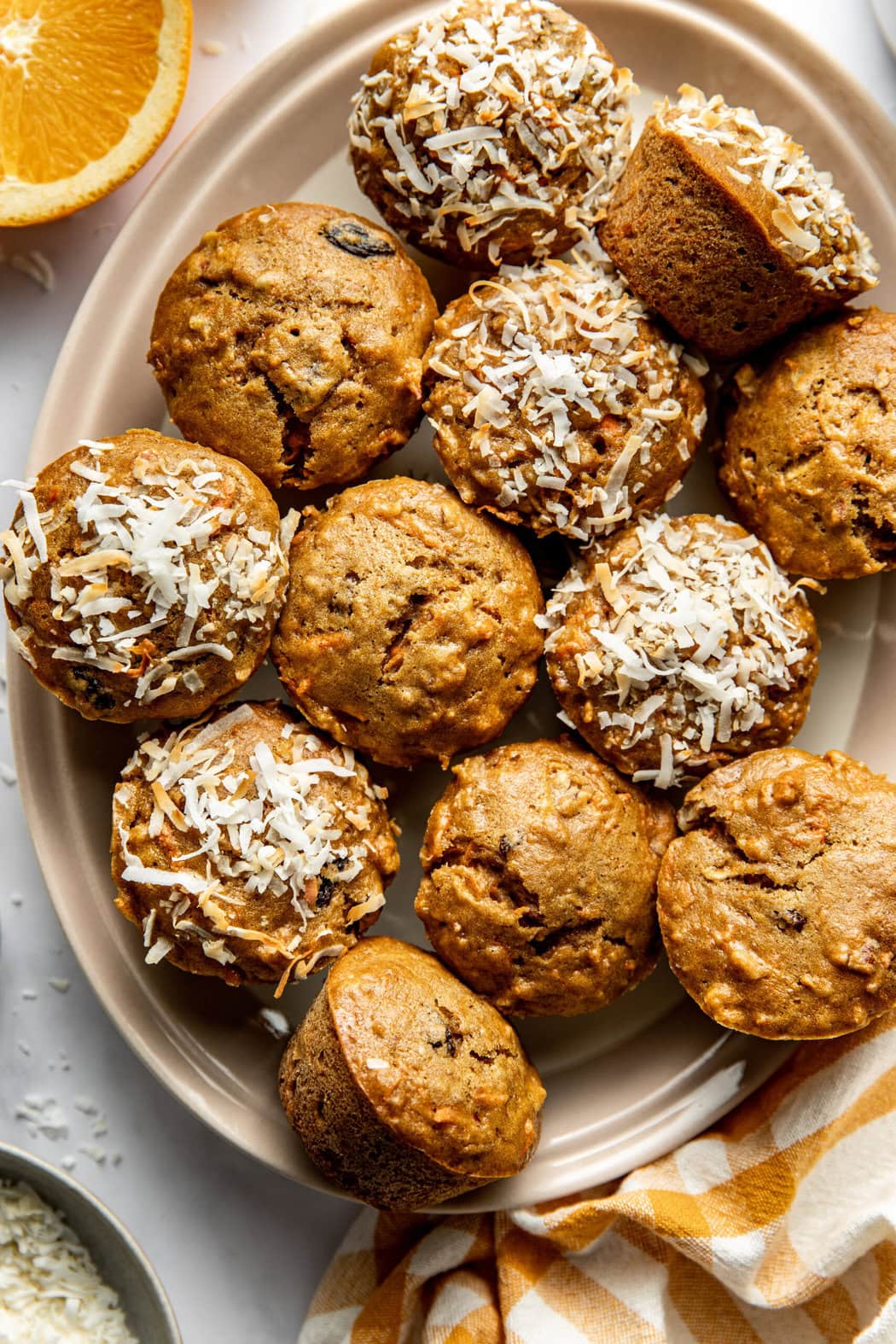 Overhead view of a plate of freshly baked Morning Glory Muffins topped with toasted coconut. 