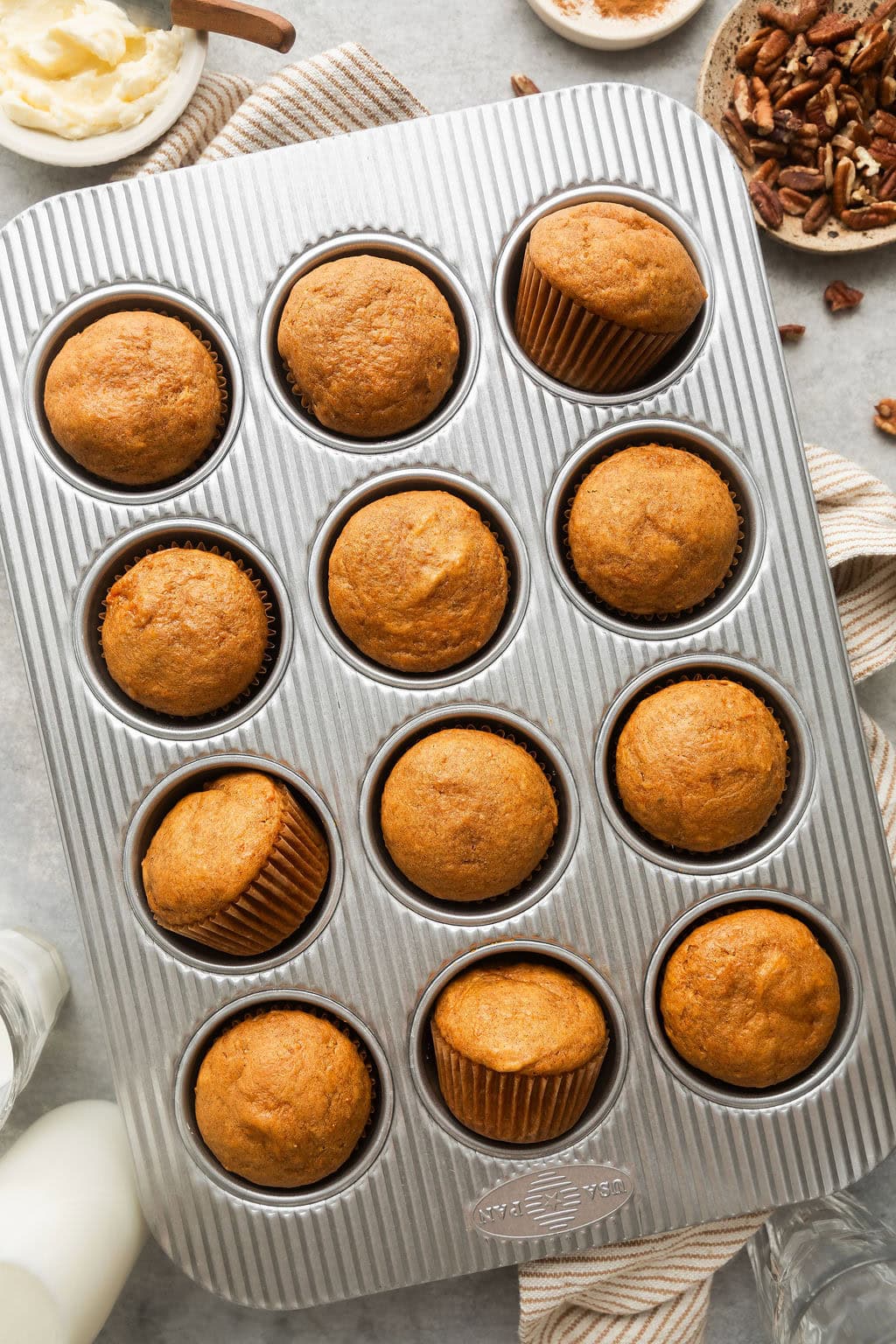 Overhead view of a metal muffin pan filled with Sweet Potato Muffins in cupcake liners.
