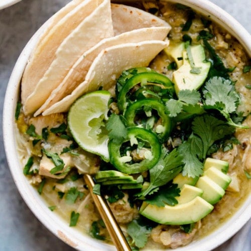 Overhead view of a bowl of Slow Cooker Chicken and Green Chile Stew topped with sliced avocado.