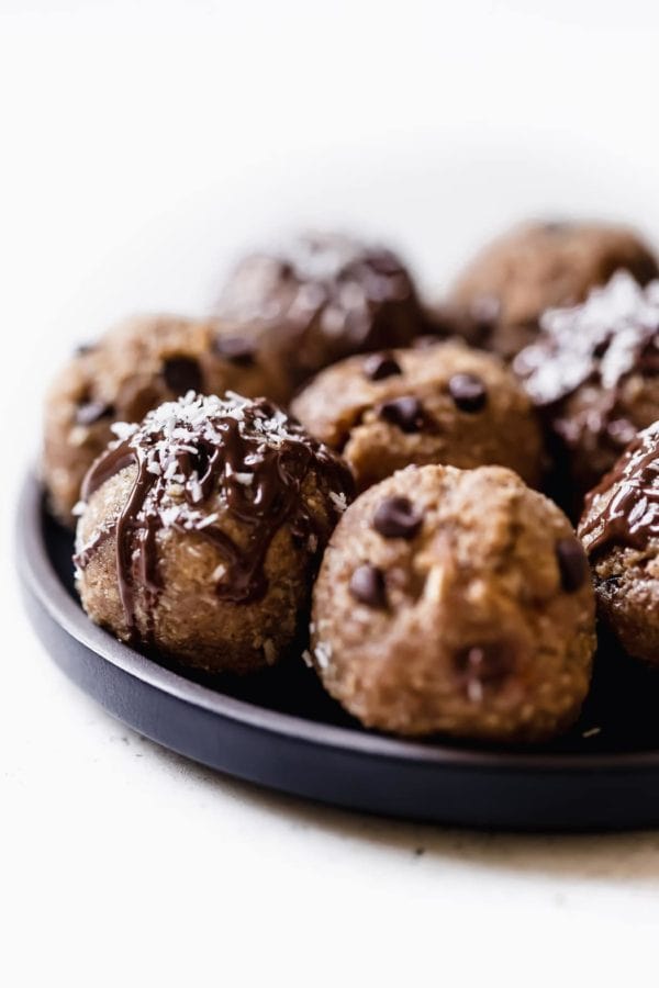 A close-up shot of a chocolate-drizzled, coconut-sprinkled Almond Joy Protein Bite.