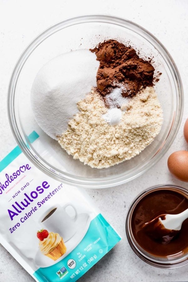 A clear glass bowl with dry ingredients to make Low Sugar Double Chocolate Mint Cookies featuring Wholesome Allulose Zero-Calorie Sweetener. 