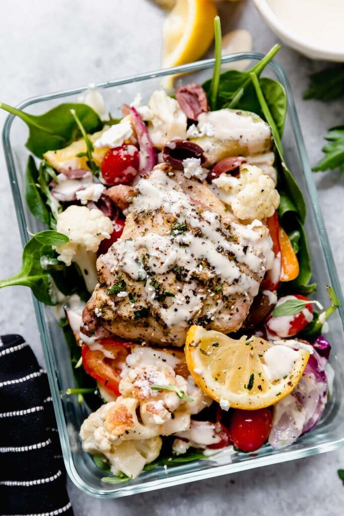 Meal prep container filled with serving of Mediterranean chicken and vegetables