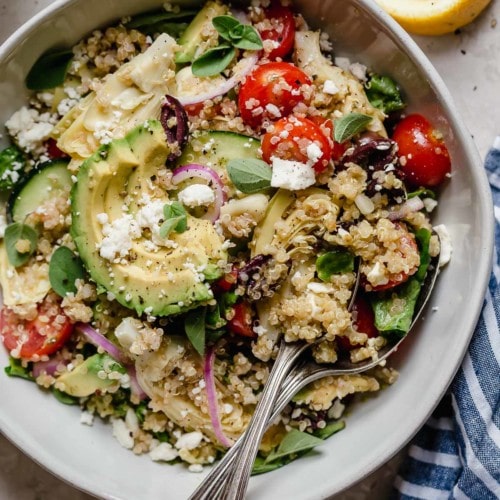 Overhead view stone bowl filled with Greek quinoa salad with feta cheese