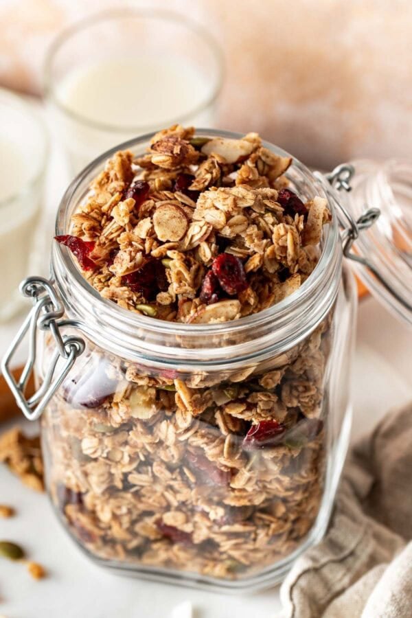 Overhead view of a glass jar filled with Homemade Granola.