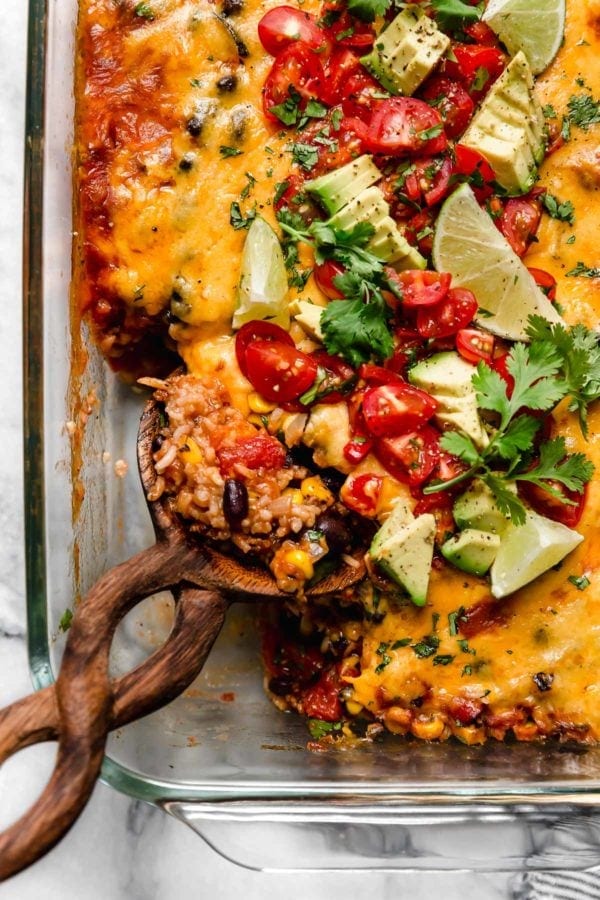 Overhead view taco casserole in baking dish with melted cheddar cheese and taco toppings.