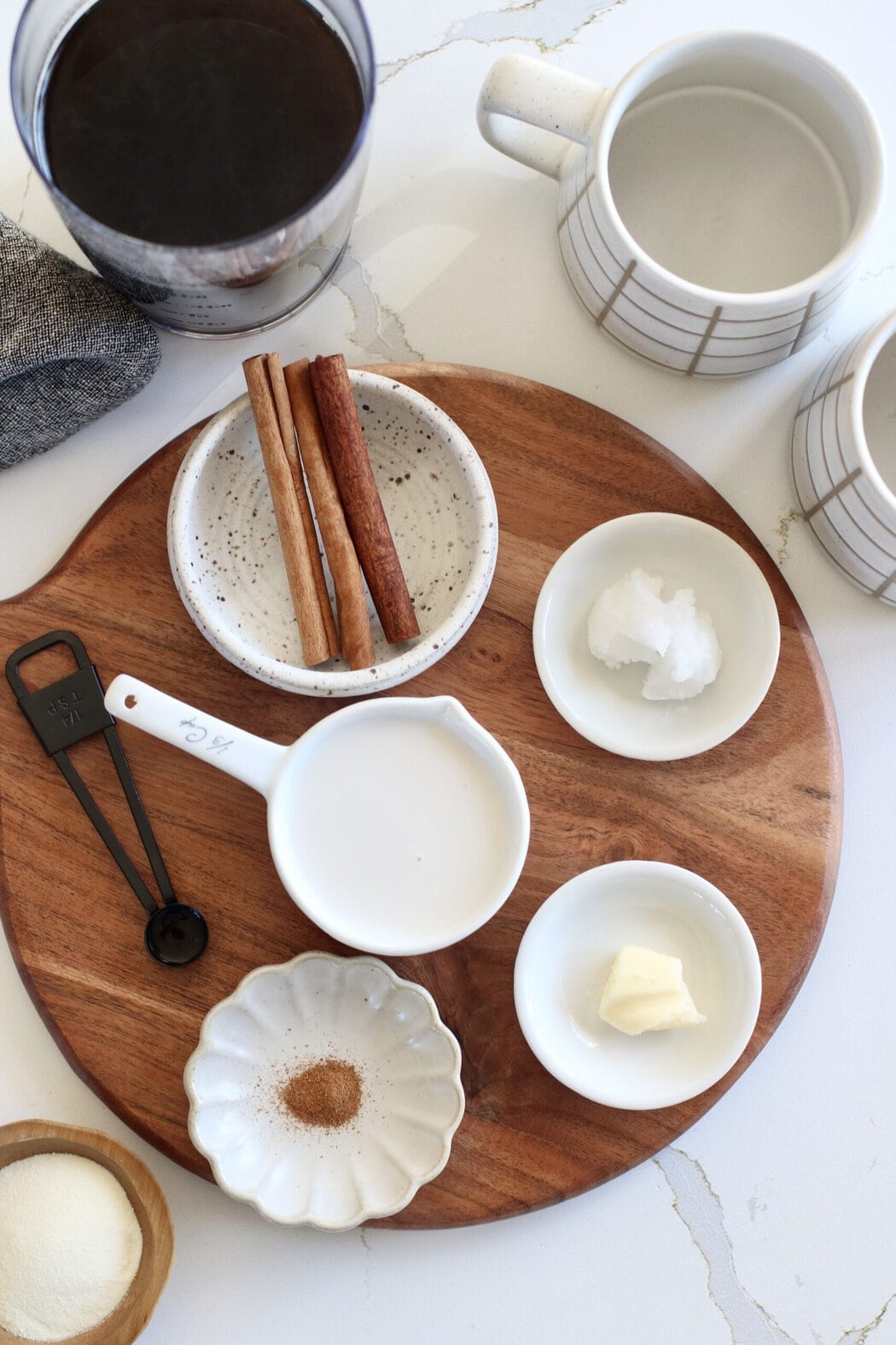 Overhead view of a variety of ingredients for Cinnamon Coconut Latte in different sized bowls. 