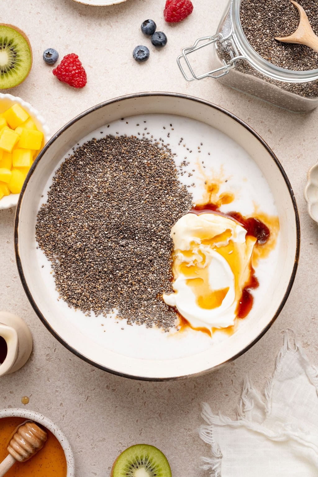 Milk, yogurt, maple syrup, and chia seeds in a bowl.