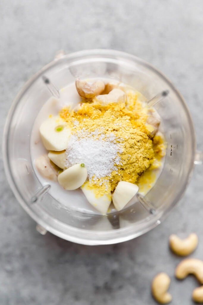 Overhead view of a blender cup filled with ingredients for a Creamy sauce