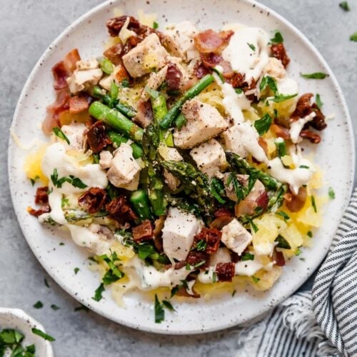 Overhead view of a plate of Creamy Chicken Spaghetti Squash with Bacon and Asparagus