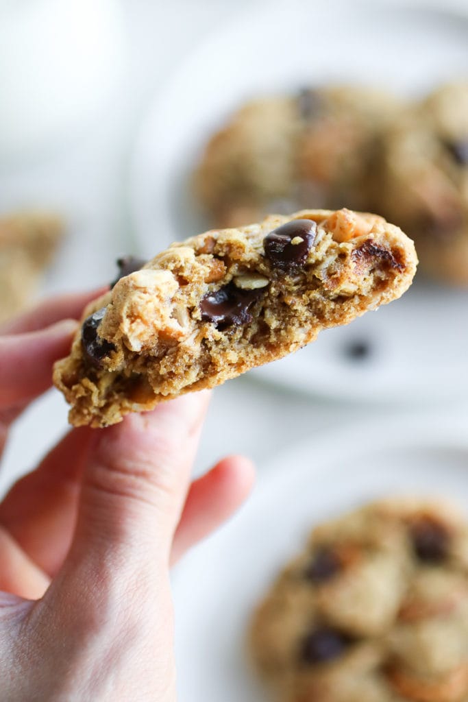 A Peanut Butter Chocolate Chip Pretzel Cookie with a bite taken out to show the perfect crumb.